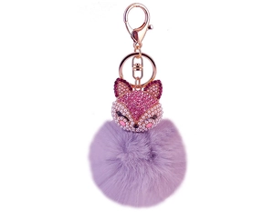 Detail showing a purple faux fur pompom keychain with a sparkling fox charm and crystals