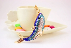 Detail of blue rhinestone shark keychain hanging on a white cup with colorful candy