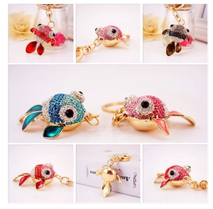 Détail des porte-clés poisson rouge en cristal en rouge, bleu, rose et noir élégant