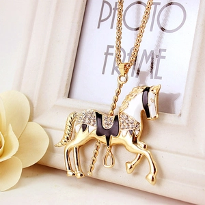 Golden carousel horse necklace with enamel detailing and sparkling rhinestones