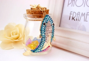 Close-up of sparkling blue rhinestone shark keychain with gold lobster clasp details