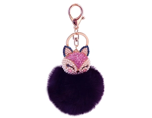 Macro view of pink rhinestone fox head keychain with large deep purple fluffy faux fur pompom