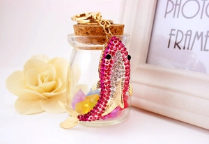 Close-up of a crystal-encrusted shark keychain with pink rhinestones and gold-tone finish