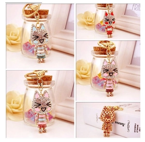 Detail view of crystal cat keychains in blue, red, and pink with golden clasps