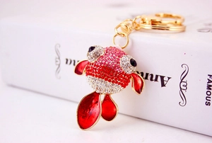 Détail du porte-clés poisson rouge avec strass roses et rouges sur alliage doré poli