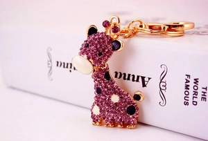Vue détaillée du porte-clés girafe avec strass violets et fermoir doré brillant