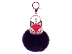 Detail of fox head keychain with red rhinestones and a fluffy deep purple fur ball
