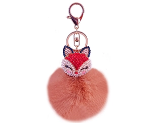 Detail of rose gold lobster clasp and crystal-encrusted fox head on pink faux fur pom pom