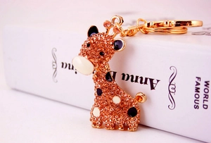 Gros plan d'un porte-clés girafe en strass avec cristaux ambrés et fermoir mousqueton doré