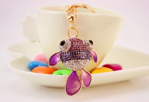Vue détaillée du porte-clés poisson avec strass violets et émail sur une tasse