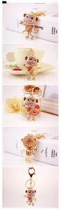 Detail showing crystal-studded monkey keychain with hollow heart metal backing