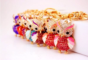 Close-up of owl keychains with colorful rhinestones and gold-tone metal hooks