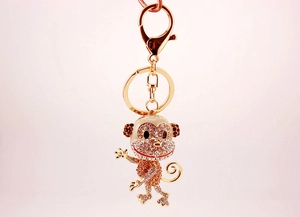Detailed macro view of a sparkling gold-plated monkey keychain with rhinestones and lobster clasp