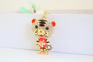 Vue macro d'un porte-clés tigre doré serti de strass et détails en émail rouge brillant