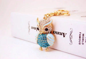 Detail of owl keychain featuring sky blue crystals and gold-plated metal finish