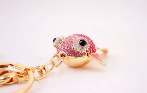 Détail du porte-clés poisson en cristal rose avec strass brillants et anneau doré