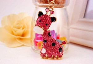 Gros plan du porte-clés girafe en strass roses avec bords dorés et émail détaillé
