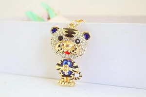Gros plan du porte-clés tigre doré avec strass brillants et détails en émail bleu