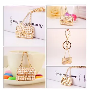 Detailed views of gold-plated mini handbag keychain with white pearls and heart cutout
