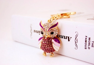 Detailed close-up of owl keychain with purple rhinestones and colorful enamel wings