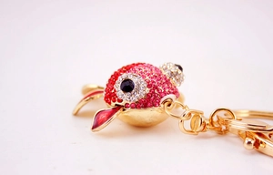Macro d'un porte-clés poisson rouge avec strass rouges et roses et fermoir homard