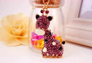 Détail du porte-clés girafe avec strass violets et base en métal doré pour sac à main