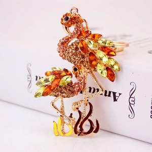 Porte-clés flamant rose scintillant avec cristaux orange sur base or rose, bijou de sac