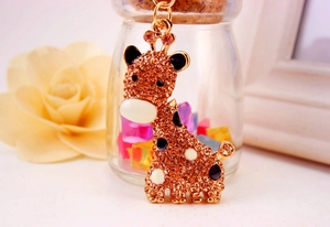 Vue détaillée du porte-clés girafe orné de strass orange scintillants et de métal doré