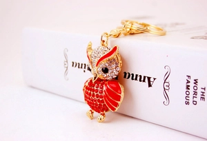 Detail of owl keychain with red enamel wings and sparkling inlaid rhinestones