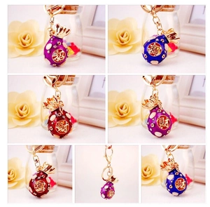 Detail view of colorful rhinestone money bag keychains with traditional lucky symbols