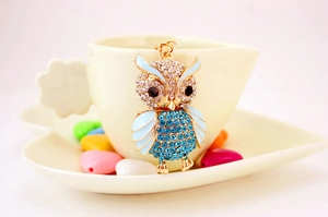 Close-up of golden owl keychain featuring blue rhinestones and light blue enamel wings