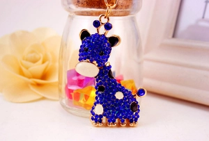 Détail du porte-clés girafe doré orné de strass bleus et de taches en émail