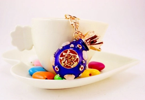 Detailed close-up of blue lucky money bag keychain with crystal stones and gold accents