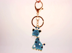 Détail macro du porte-clés girafe avec strass bleus et placage en alliage métallique doré