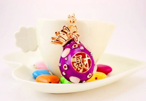 Detail view of purple enamel money bag keychain with crystal rhinestones and gold plating