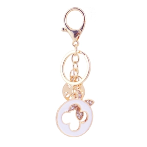 Golden keychain with lobster clasp featuring white enamel four-leaf clover and crystal butterfly