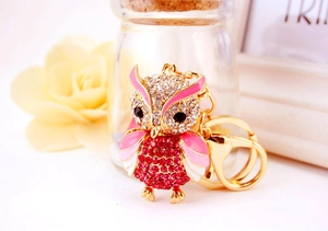 Detailed view of pink owl keychain with sparkling crystals and enamel wings