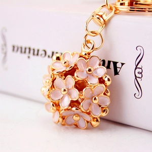 Pink daisy floral keychain bag charm featuring 3D hollow petals and gold metal finish