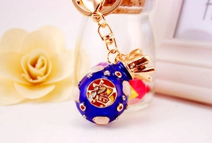 Detail of blue enamel money bag keychain with gold plating and sparkling crystals