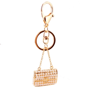 Elegant gold keychain with pearl-studded handbag charm and lobster clasp for women