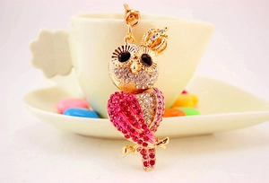 Detailaufnahme der Eulen-Schlüsselanhänger mit rosa und weißen Strasssteinen und Goldkrone