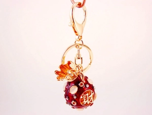 Detailed close-up of a red lucky fortune bag keychain with golden character engraving