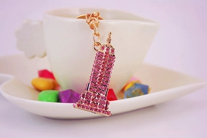 Detail van een Eiffeltoren sleutelhanger met roze strass hangend aan een witte mok