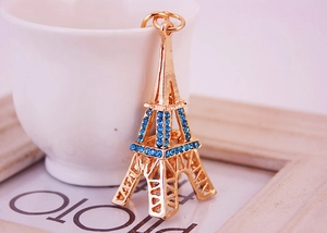 Vue détaillée du porte-clés Tour Eiffel doré orné de strass bleus et d'un anneau en métal