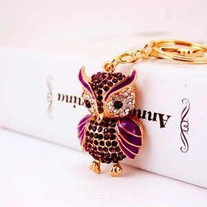 Exquisite owl keychain with purple crystals and gold alloy plating on white background