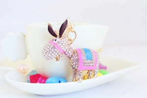 Detail of rhinestone donkey keychain hanging on a white coffee cup as a cute bag accessory