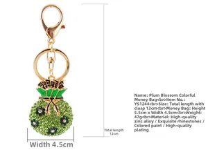 Détail d'un porte-clés sac d'argent vert avec strass et motifs de fleurs de prunier