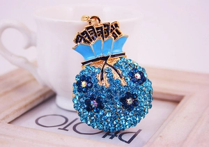 Gros plan du pendentif sac de fortune en strass bleu avec émail et plaquage en or