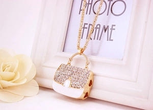 Detail-Makroaufnahme eines goldenen Taschenanhängers mit Strass und Emaille-Finish