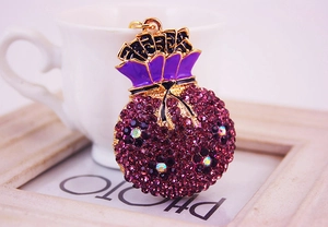 Gros plan d'un porte-clés sac à monnaie vintage avec strass violets et détails dorés